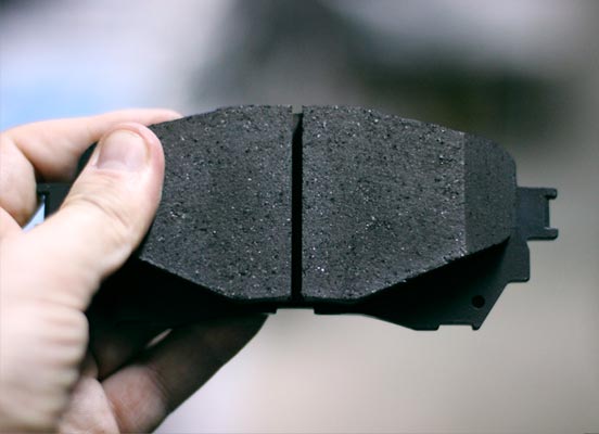 close up of hand holding a brake pad